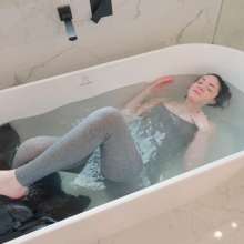 WetlookFashion: Elena Takes a Bath in a Jumpsuit, Boots and Leather Jacket